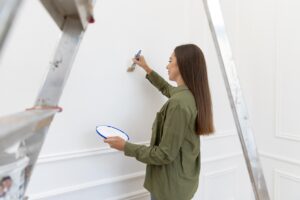donna che realizza decorazione sulla parete