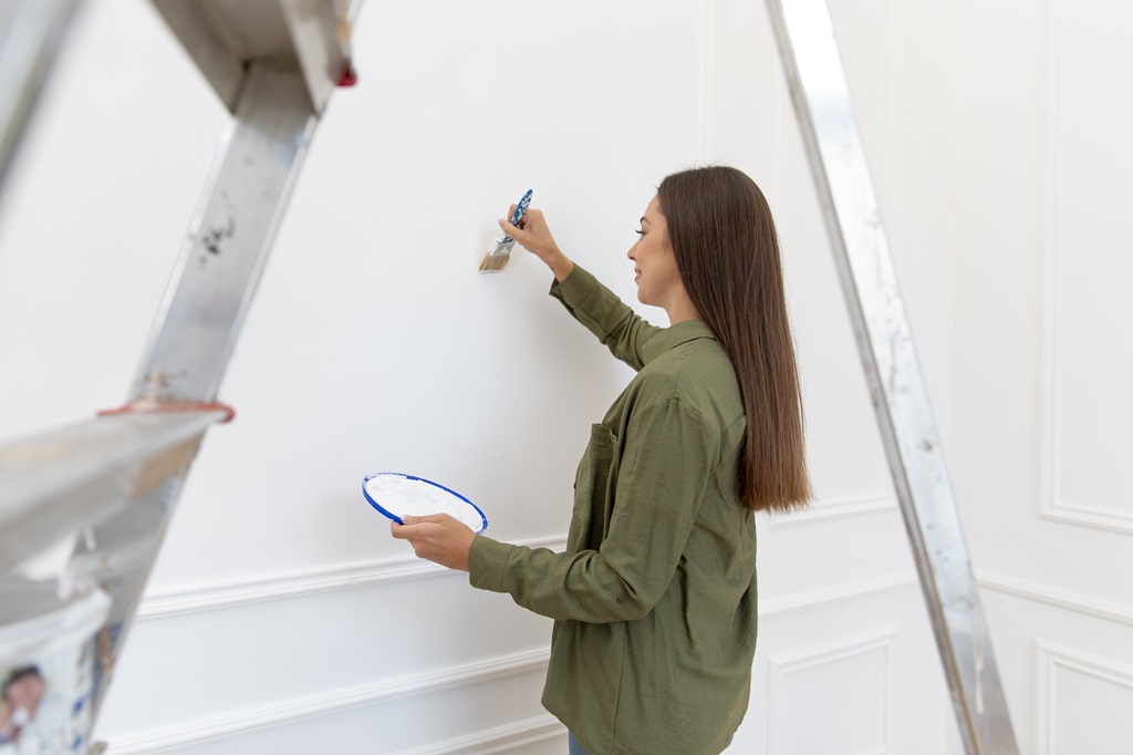 donna che realizza decorazione sulla parete