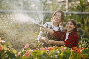 madre-con-figlia-innaffia-fiori-Giardino a Basso Consumo Idrico
