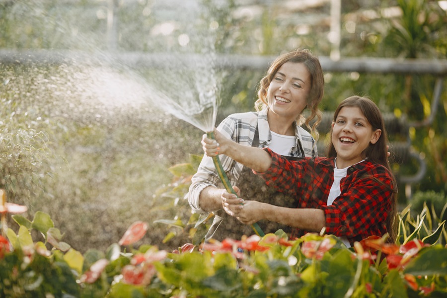 madre-con-figlia-innaffia-fiori-Giardino a Basso Consumo Idrico